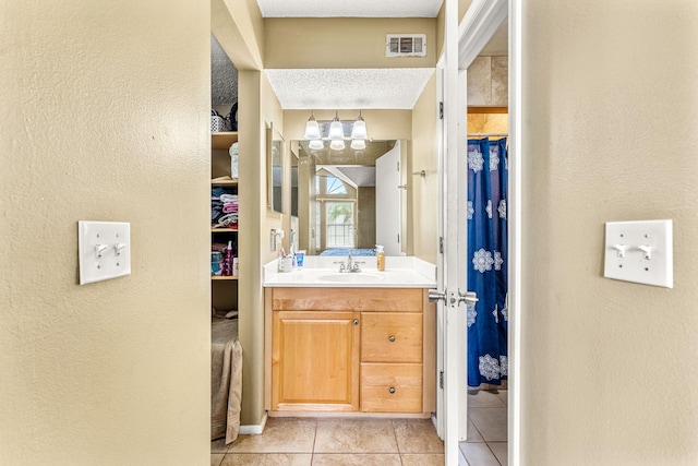 bathroom featuring vanity, tile patterned flooring, a shower with shower curtain, and a textured ceiling