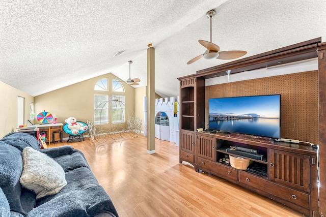 living room featuring ceiling fan, a textured ceiling, light hardwood / wood-style floors, and lofted ceiling