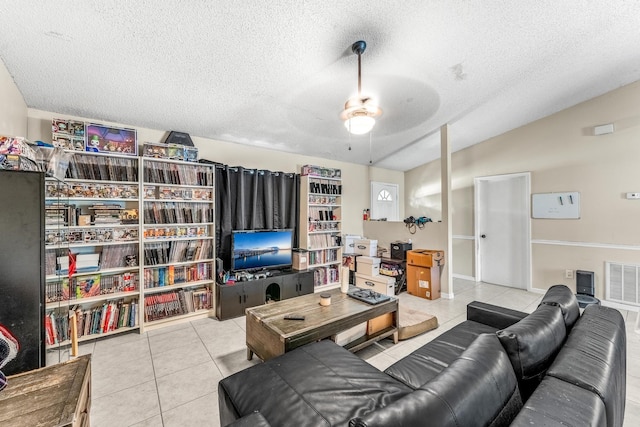 tiled living room with a textured ceiling and ceiling fan