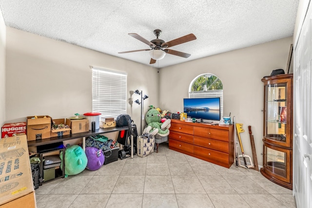 interior space with tile patterned floors, a textured ceiling, and ceiling fan