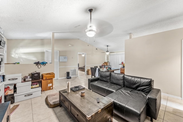 tiled living room with a textured ceiling, ceiling fan, and lofted ceiling