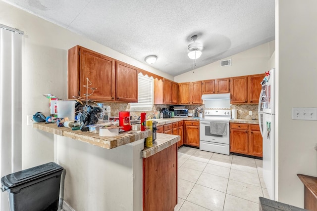 kitchen with tasteful backsplash, white appliances, kitchen peninsula, light tile patterned floors, and ceiling fan