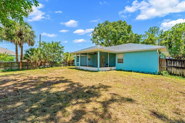 back of property with a sunroom and a yard