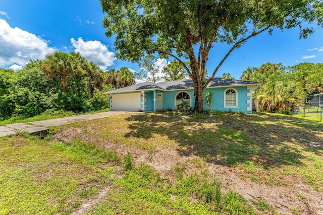 single story home with a garage and a front lawn