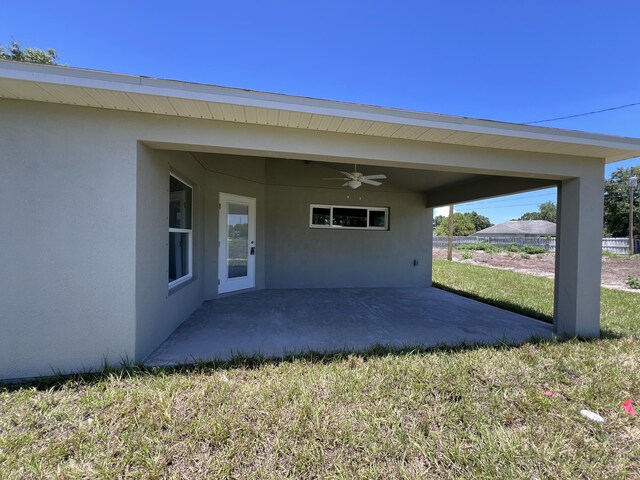 back of house with a patio, ceiling fan, and a lawn