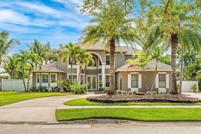 mediterranean / spanish-style home featuring french doors and a front lawn