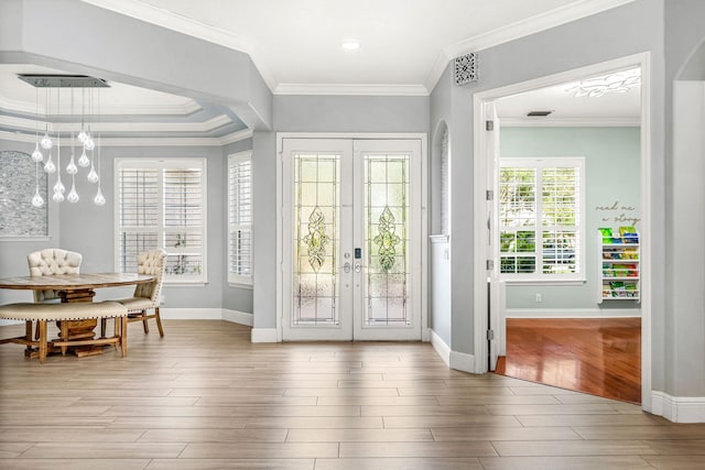 doorway with ornamental molding, french doors, hardwood / wood-style floors, and a chandelier