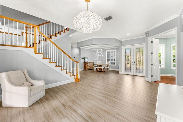 entryway with ornamental molding, french doors, hardwood / wood-style floors, and a chandelier