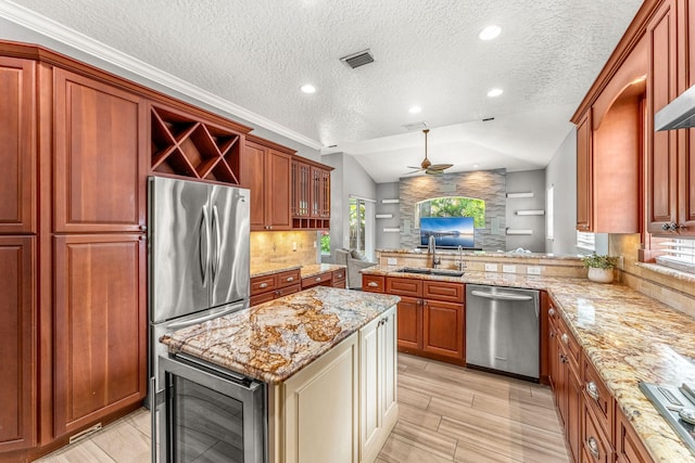 kitchen with vaulted ceiling, ceiling fan, tasteful backsplash, wine cooler, and appliances with stainless steel finishes