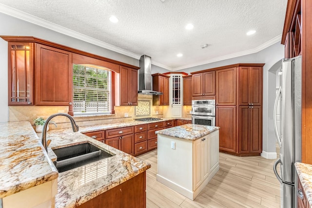 kitchen featuring sink, a center island, light stone counters, and wall chimney exhaust hood