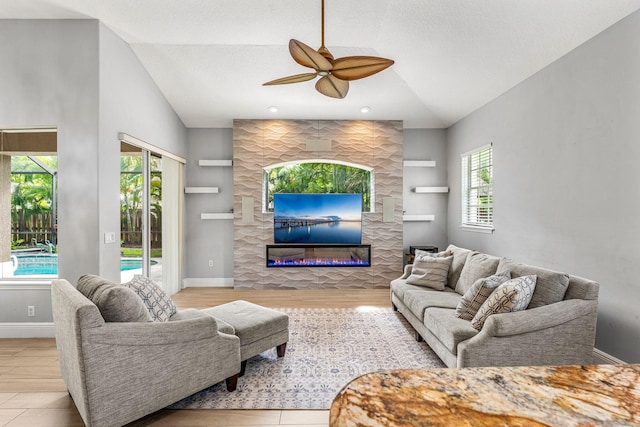 living room with ceiling fan, a healthy amount of sunlight, lofted ceiling, and built in shelves