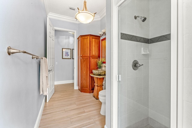 bathroom with ornamental molding, walk in shower, and toilet