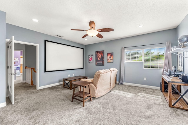 carpeted cinema featuring a textured ceiling and ceiling fan