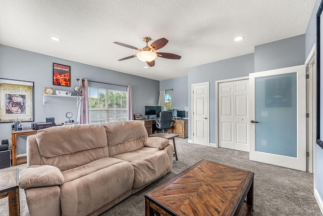 living room featuring a textured ceiling, ceiling fan, and carpet