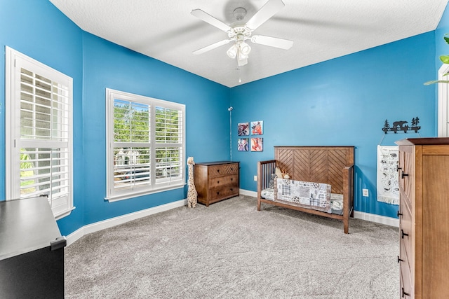 bedroom with ceiling fan, carpet floors, and a textured ceiling