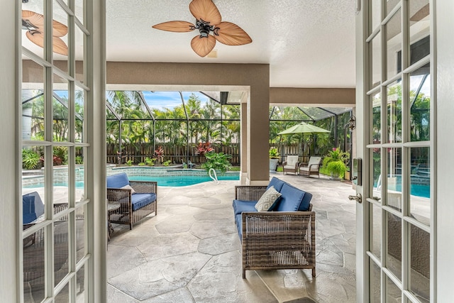 sunroom with a wealth of natural light, ceiling fan, and a pool