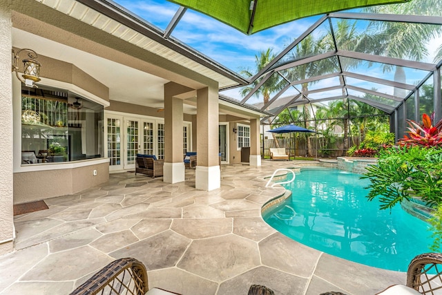 view of pool with ceiling fan, a lanai, a patio, and french doors