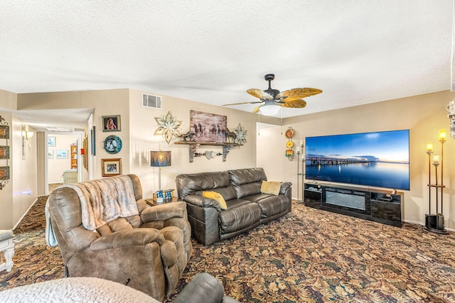 living room with a textured ceiling, ceiling fan, and carpet flooring