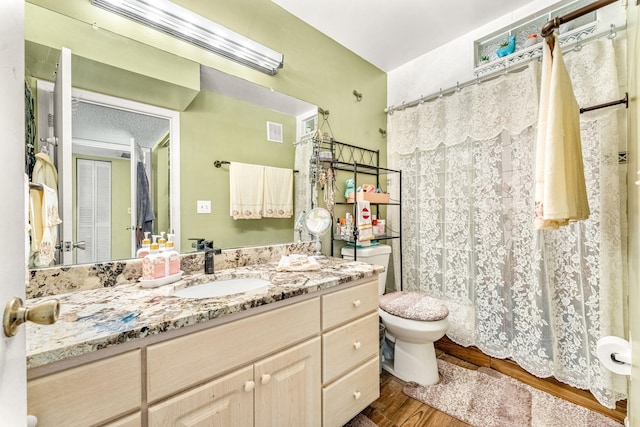 bathroom with toilet, wood-type flooring, and vanity