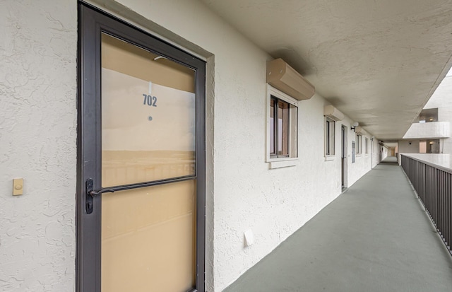 property entrance with a balcony and stucco siding