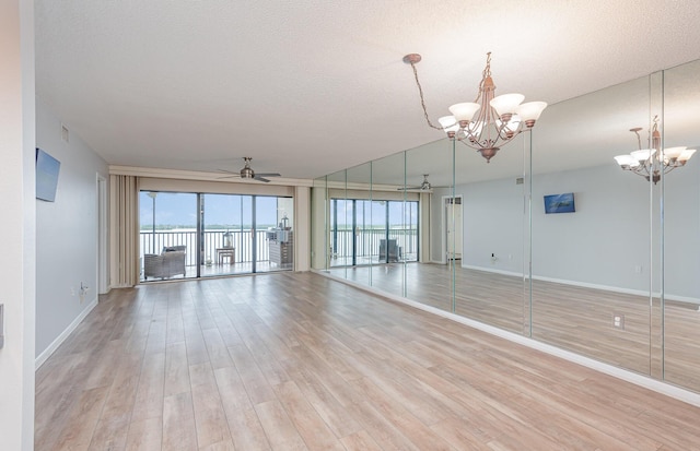 spare room featuring a textured ceiling, light hardwood / wood-style flooring, and a healthy amount of sunlight