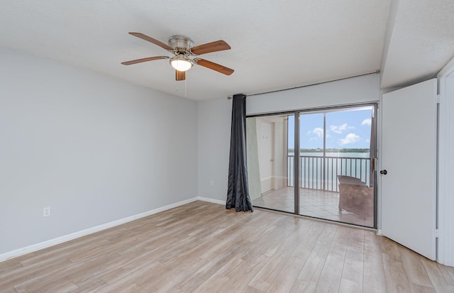 unfurnished bedroom featuring a textured ceiling, access to outside, light wood-type flooring, and ceiling fan