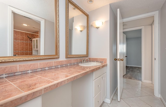 bathroom with vanity, a textured ceiling, and tile patterned flooring