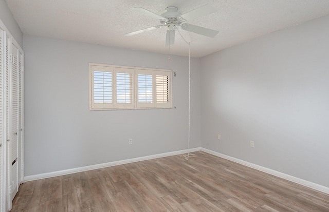 unfurnished bedroom with wood-type flooring, a textured ceiling, a closet, and ceiling fan