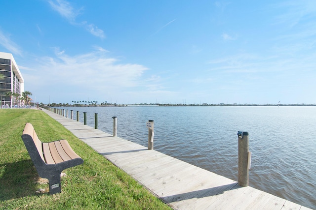 dock area with a water view and a lawn