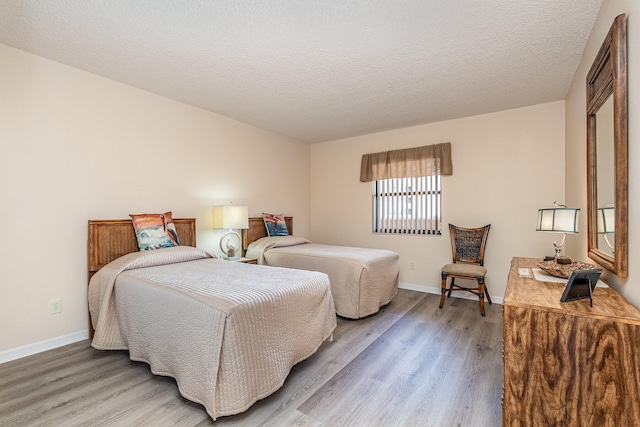 bedroom featuring light wood-type flooring and a textured ceiling