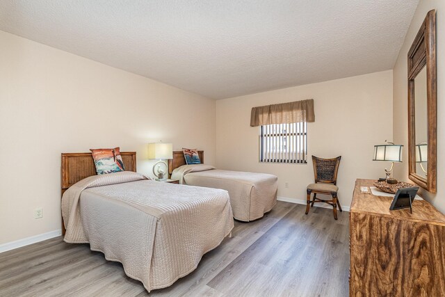 1860 N Atlantic Ave Unit 604, Cocoa Beach, FL 32931 - bedroom featuring baseboards, a textured ceiling, and light wood finished floors