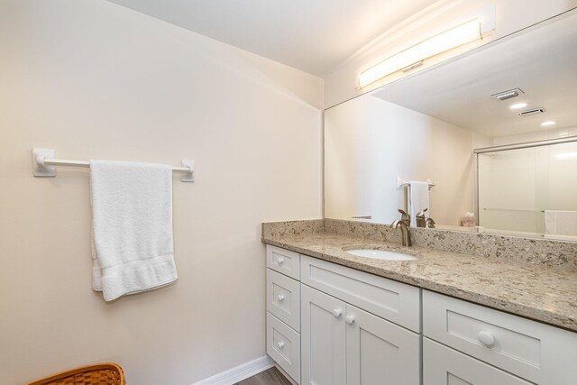 1860 N Atlantic Ave Unit 604, Cocoa Beach, FL 32931 - full bath featuring an enclosed shower, visible vents, vanity, and baseboards