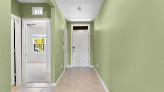 hallway with light tile patterned floors and a textured ceiling