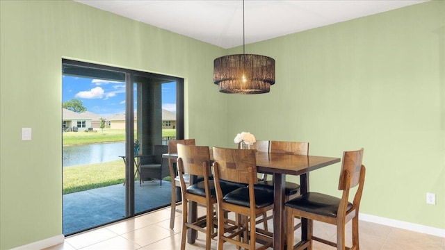 dining space with a water view and light tile patterned floors