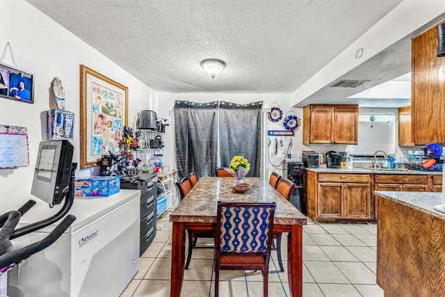 kitchen with light tile patterned floors, sink, and a textured ceiling