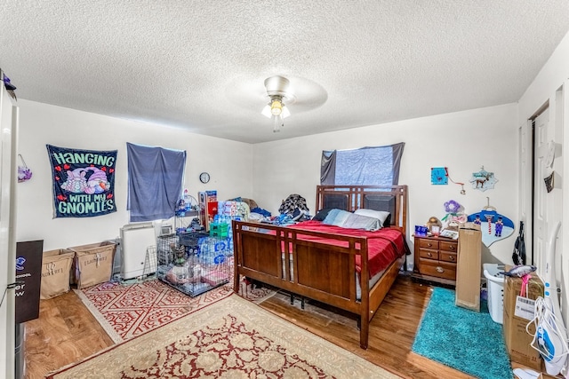 bedroom featuring hardwood / wood-style floors, a textured ceiling, and ceiling fan