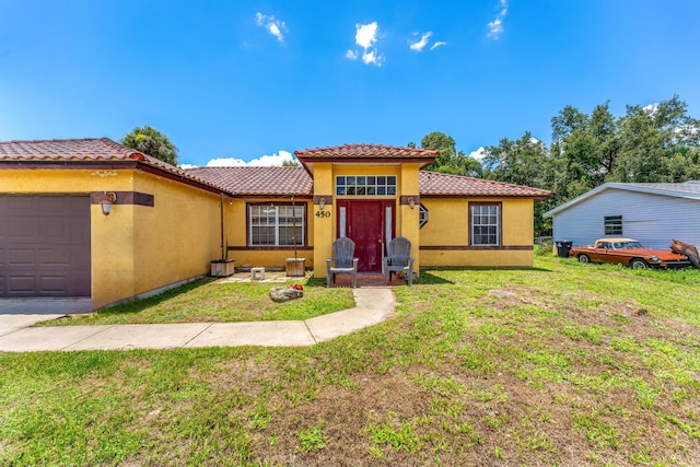 mediterranean / spanish-style house with a garage and a front yard