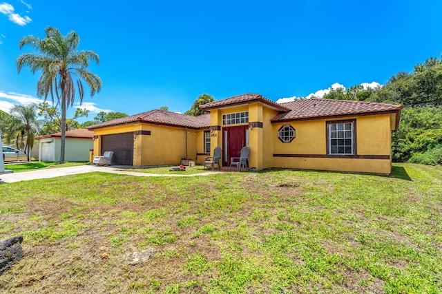 mediterranean / spanish home with a garage and a front yard