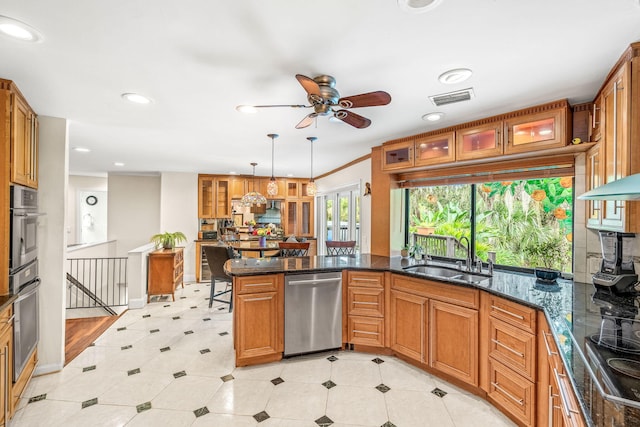 kitchen featuring sink, dark stone countertops, hanging light fixtures, stainless steel appliances, and kitchen peninsula