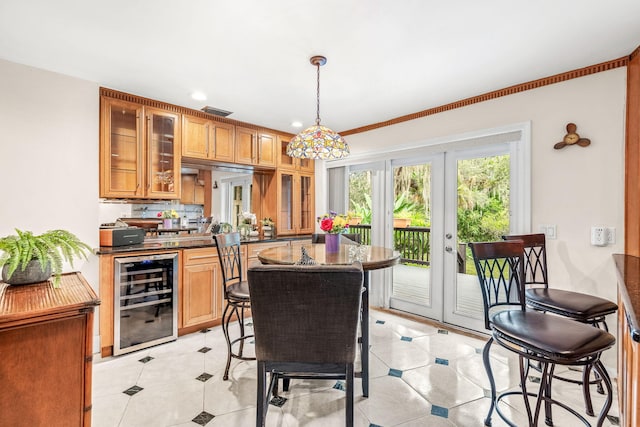 kitchen featuring hanging light fixtures, light tile patterned floors, beverage cooler, and french doors