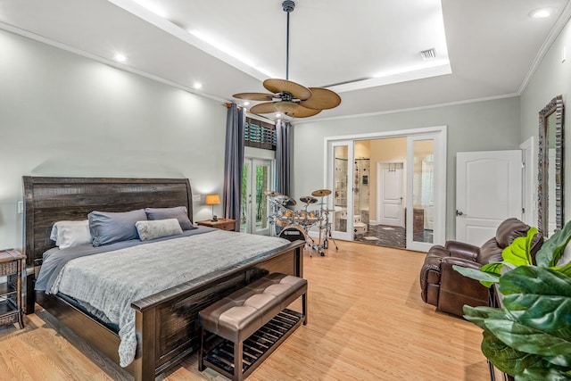 bedroom featuring crown molding, hardwood / wood-style floors, ceiling fan, and ensuite bath