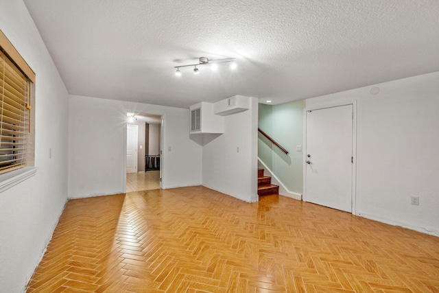 interior space with light parquet floors and a textured ceiling