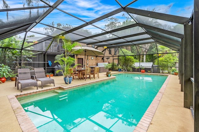 view of swimming pool with a fireplace, a jacuzzi, a patio area, and glass enclosure