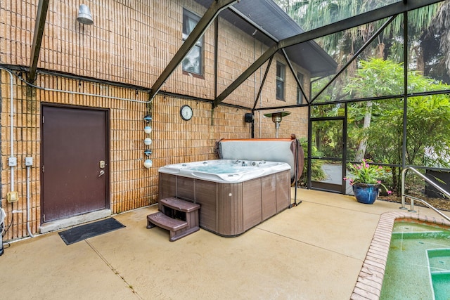 view of patio / terrace featuring a lanai and a hot tub