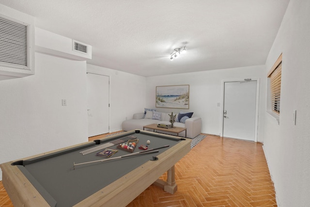 game room with parquet floors, pool table, and a textured ceiling