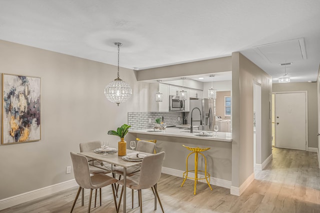 dining area with sink and light hardwood / wood-style floors