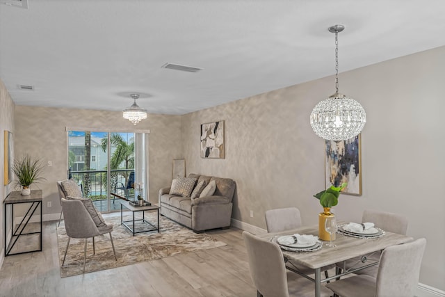 living room with light wood-type flooring and a notable chandelier