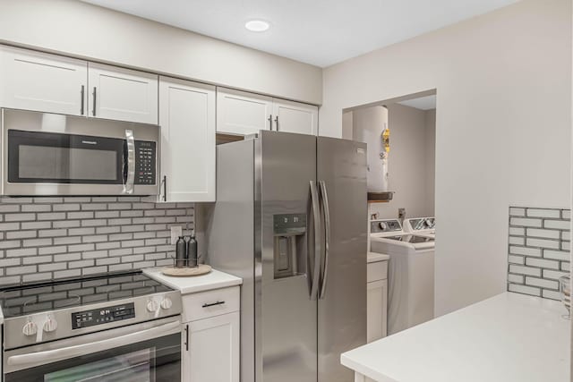 kitchen featuring backsplash, appliances with stainless steel finishes, separate washer and dryer, and white cabinets