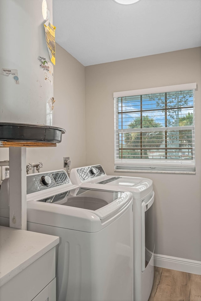 clothes washing area featuring light hardwood / wood-style flooring and washer and dryer