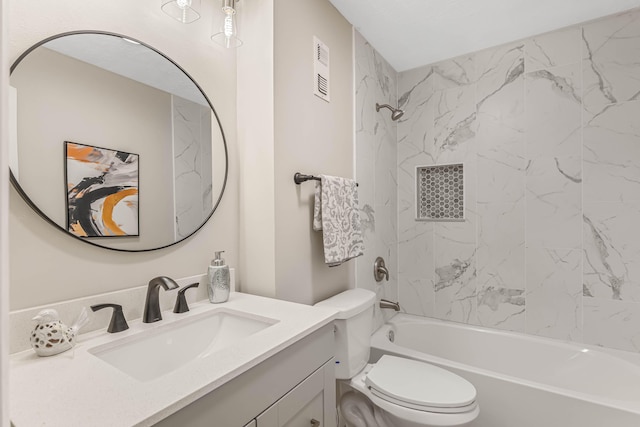 full bathroom featuring tiled shower / bath, vanity, and toilet